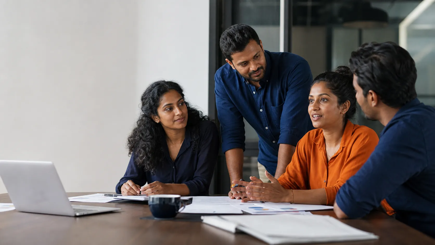 Diverse Australian workplace team including Sri Lankan-Australian colleagues discussing a project around a table