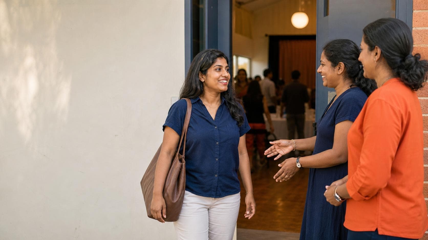 First-time attendee receiving a warm welcome at the entrance to a modest Sri Lankan-Australian community event